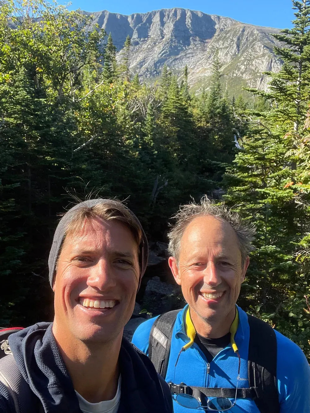 Two hikers standing in front of a mountain