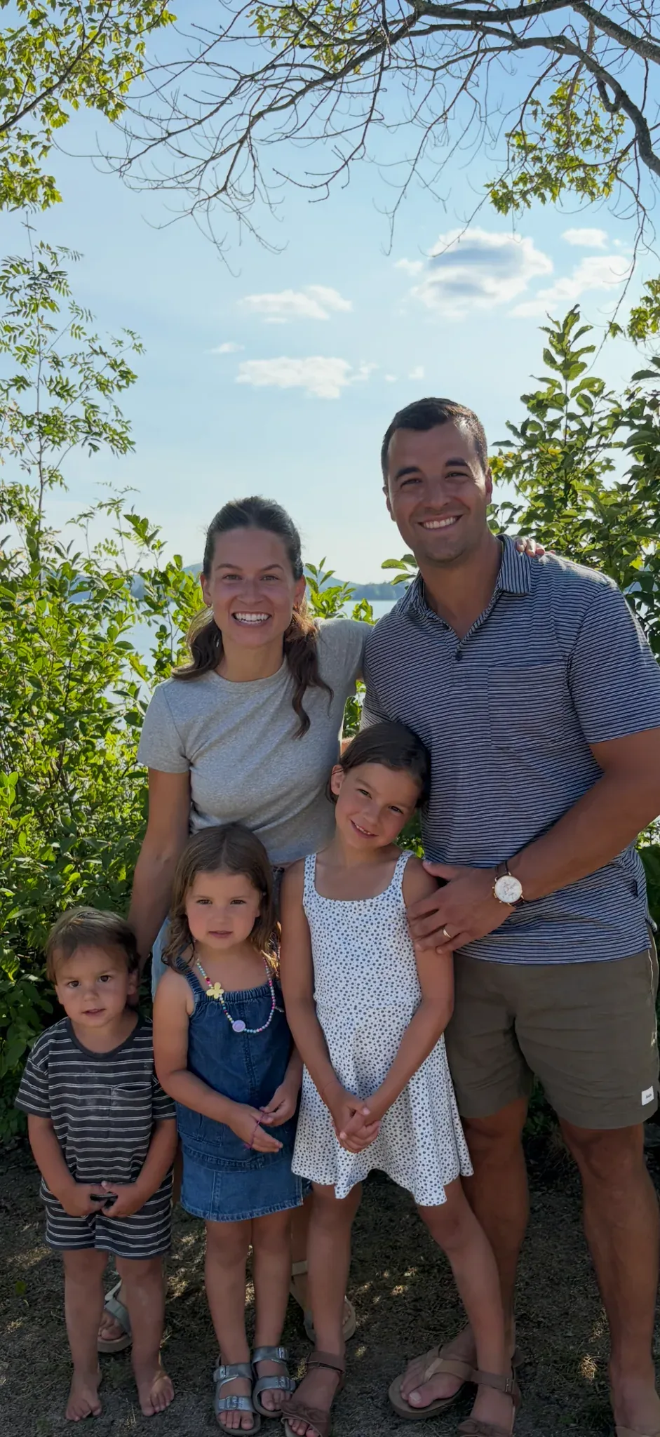 A family standing outdoors near the water